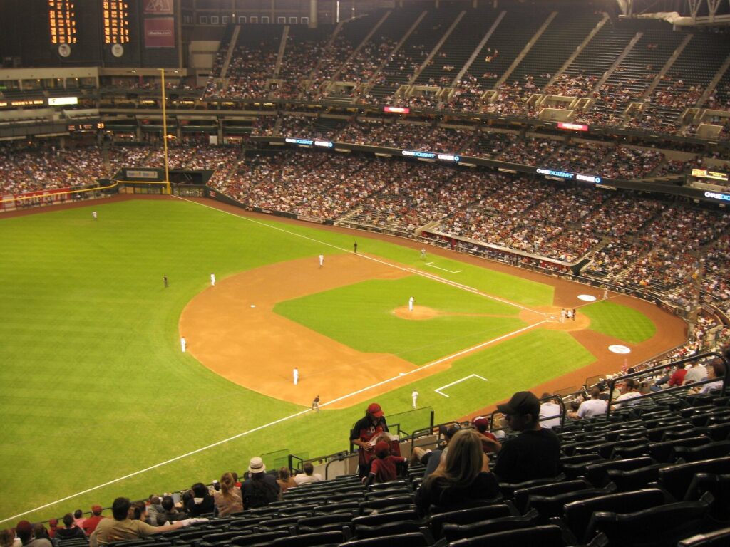 The infield and packed stands inside Chase Field during a Diamondbacks game, with the roof closed and the scoreboard lit
