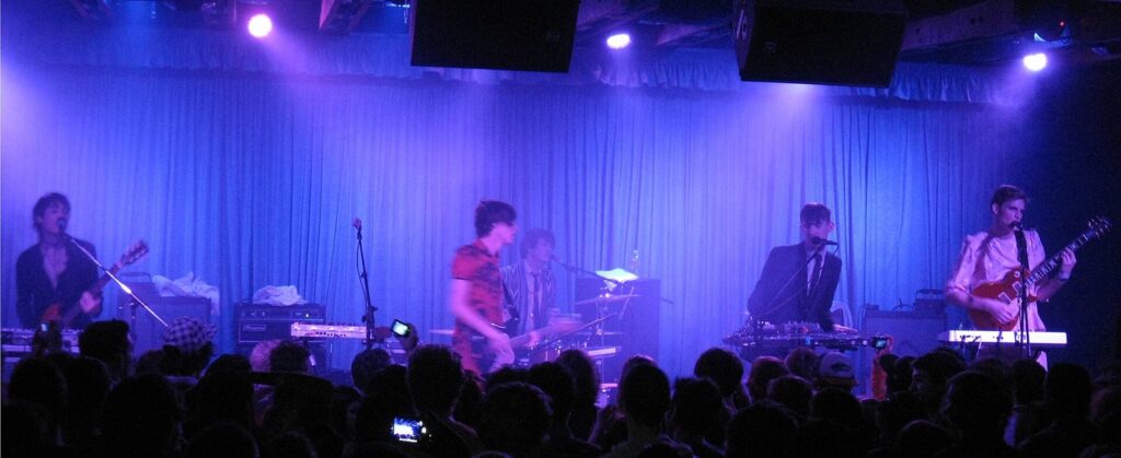 A band playing under blue stage lights to a packed crowd at Crescent Ballroom, a downtown staple of Phoenix nightlife