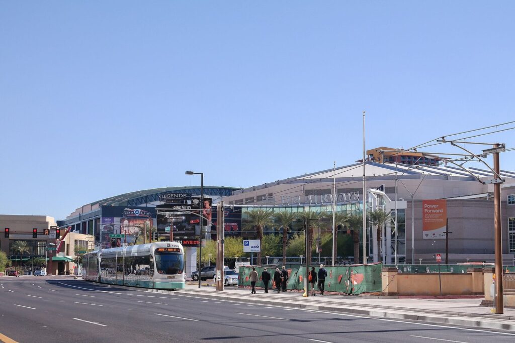 A light rail train passing the arena on Jefferson Street in downtown Phoenix, an easy way to reach NBA All Star 2027