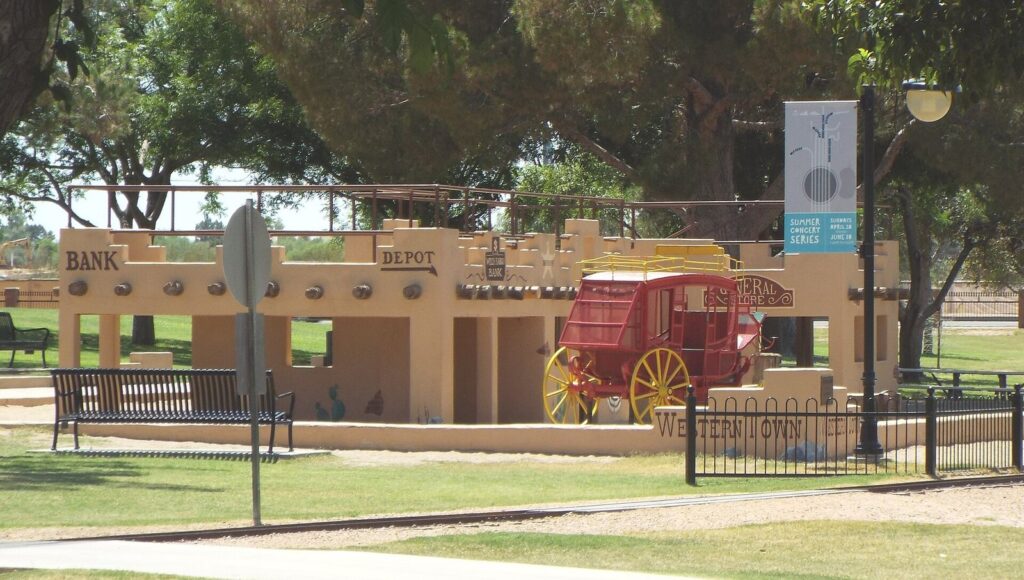 A children's play area built like a small Western town, with a red stagecoach, a depot and a bank facade, at McCormick-Stillman Railroad Park