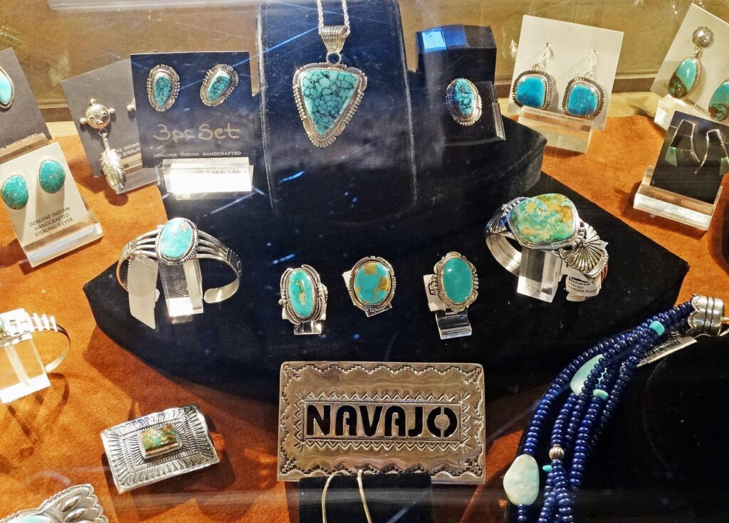 Turquoise and silver rings, bracelets, earrings and a Navajo belt buckle displayed in a glass case at a trading post