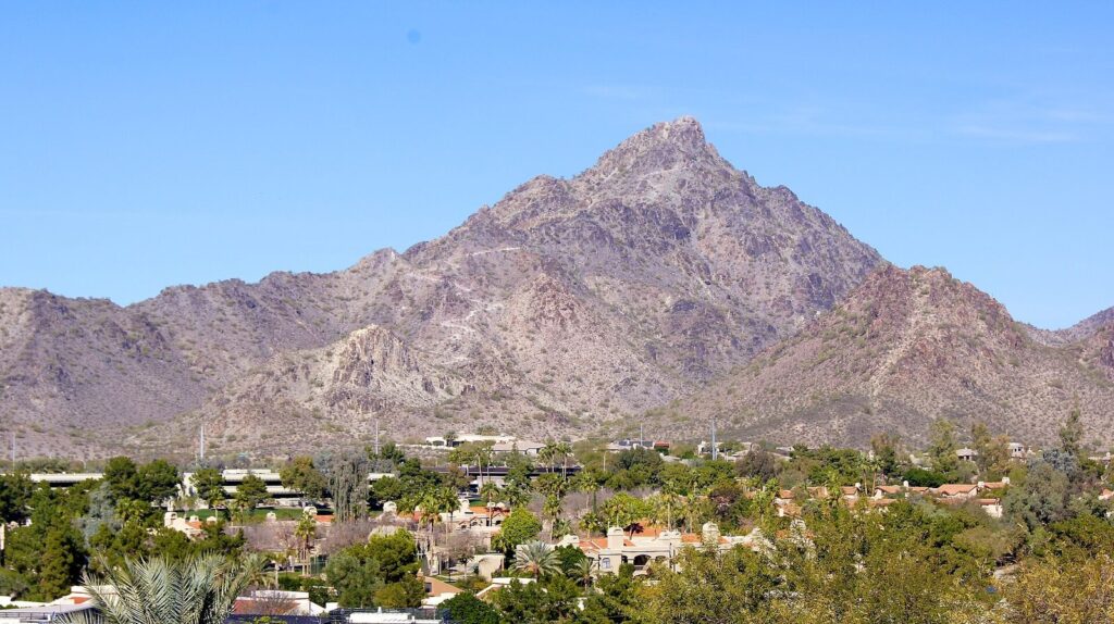 The pointed summit of Piestewa Peak rising above houses and desert trees, a favorite of Phoenix in November hikers