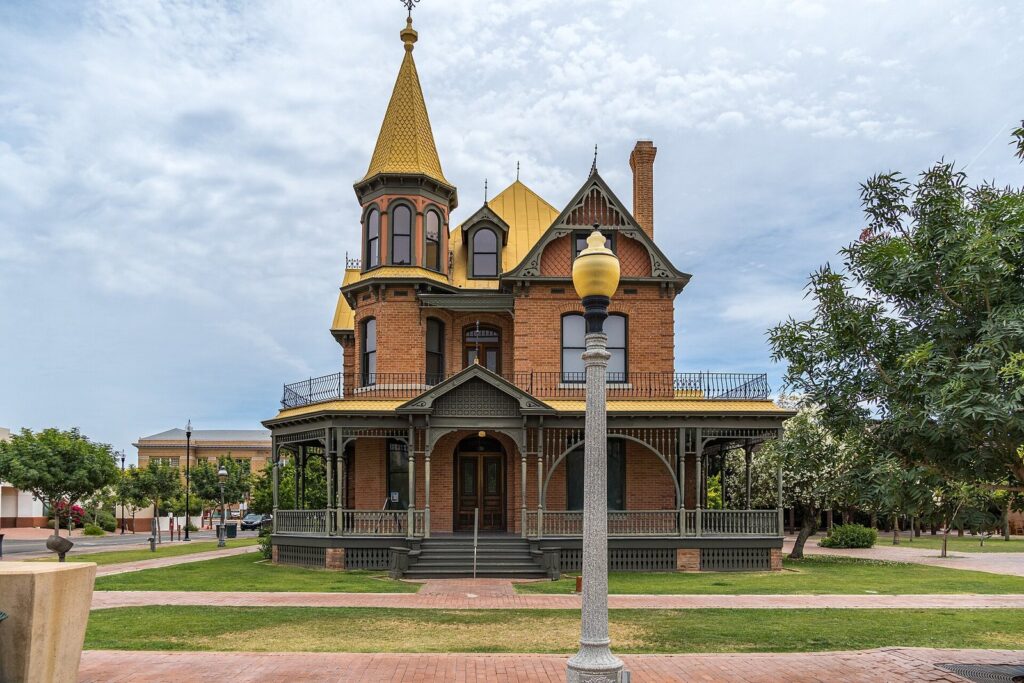 The red-brick Victorian Rosson House with its gold-roofed turret, surrounded by lawn and trees at The Square PHX in downtown Phoenix