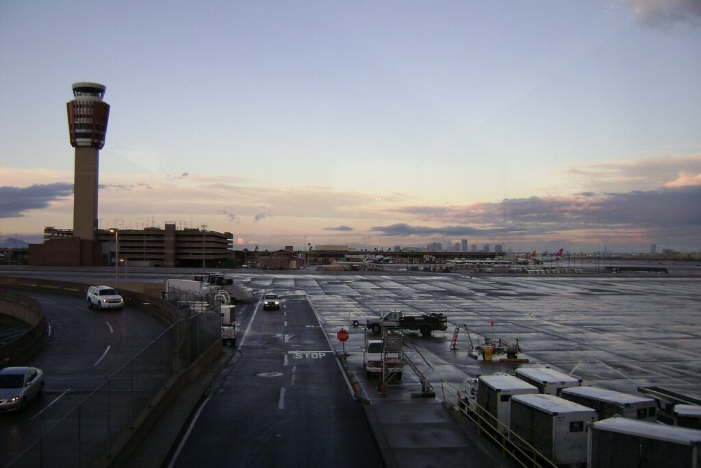 The Sky Harbor control tower and Terminal 3 parking garage at dusk with the downtown Phoenix skyline behind