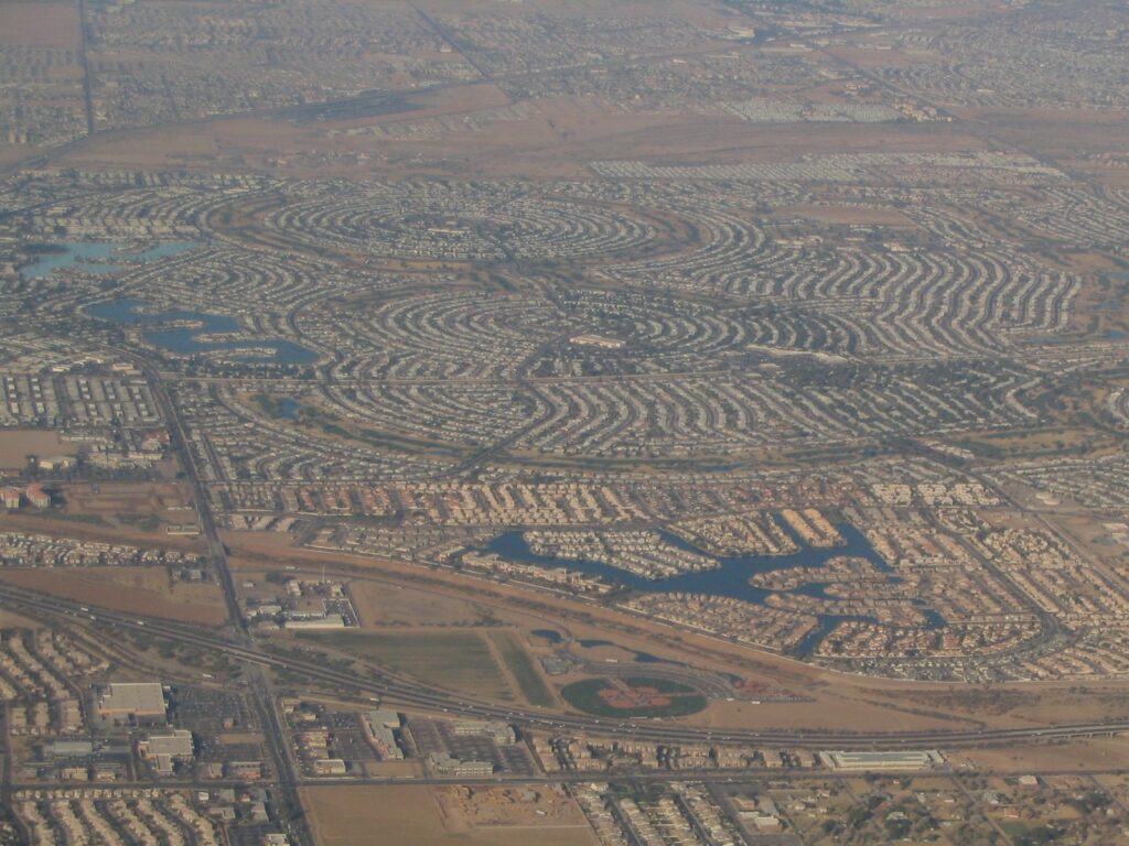 Aerial view of Sun City, a classic winter base for snowbirds in Arizona, showing its circular streets, golf courses and lakes spreading across the desert