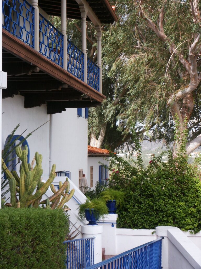 White walls, blue-painted balcony railings and desert plants at the Wrigley Mansion in Phoenix