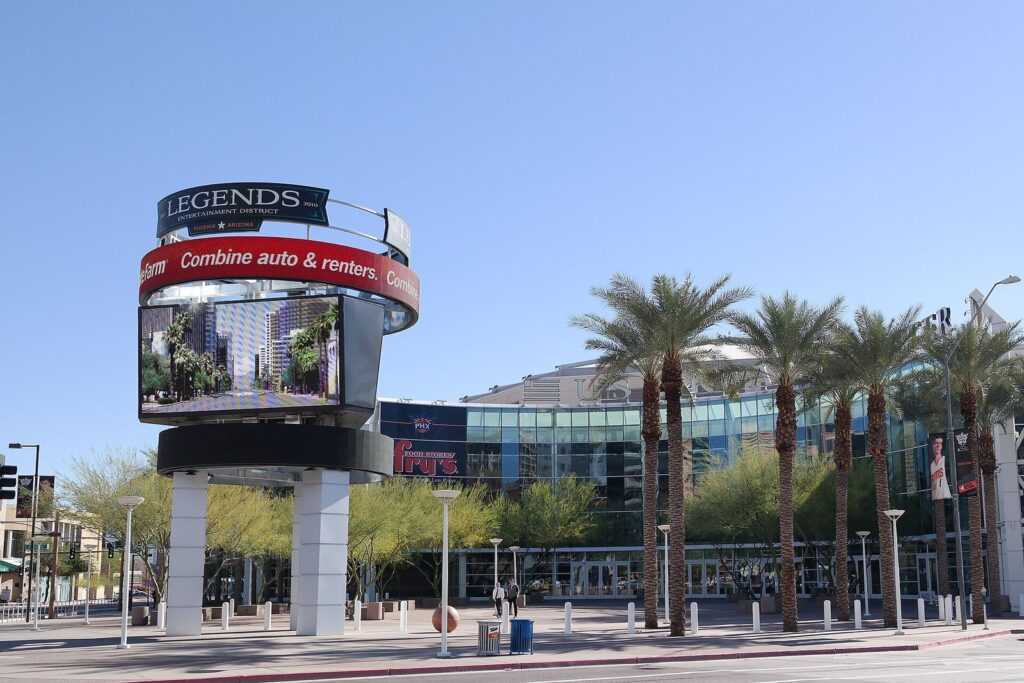 The arena's palm-lined entrance plaza on Jefferson Street in downtown Phoenix with a tall video sign tower