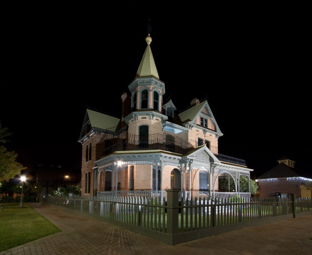 The Victorian Rosson House with its turret and wraparound porch lit at night in downtown Phoenix