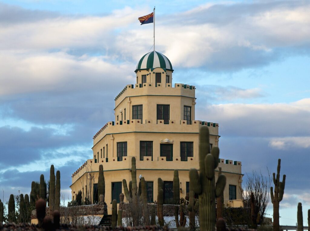 Tovrea Castle's tiered cream-colored tower with a green-striped cupola rising above saguaros